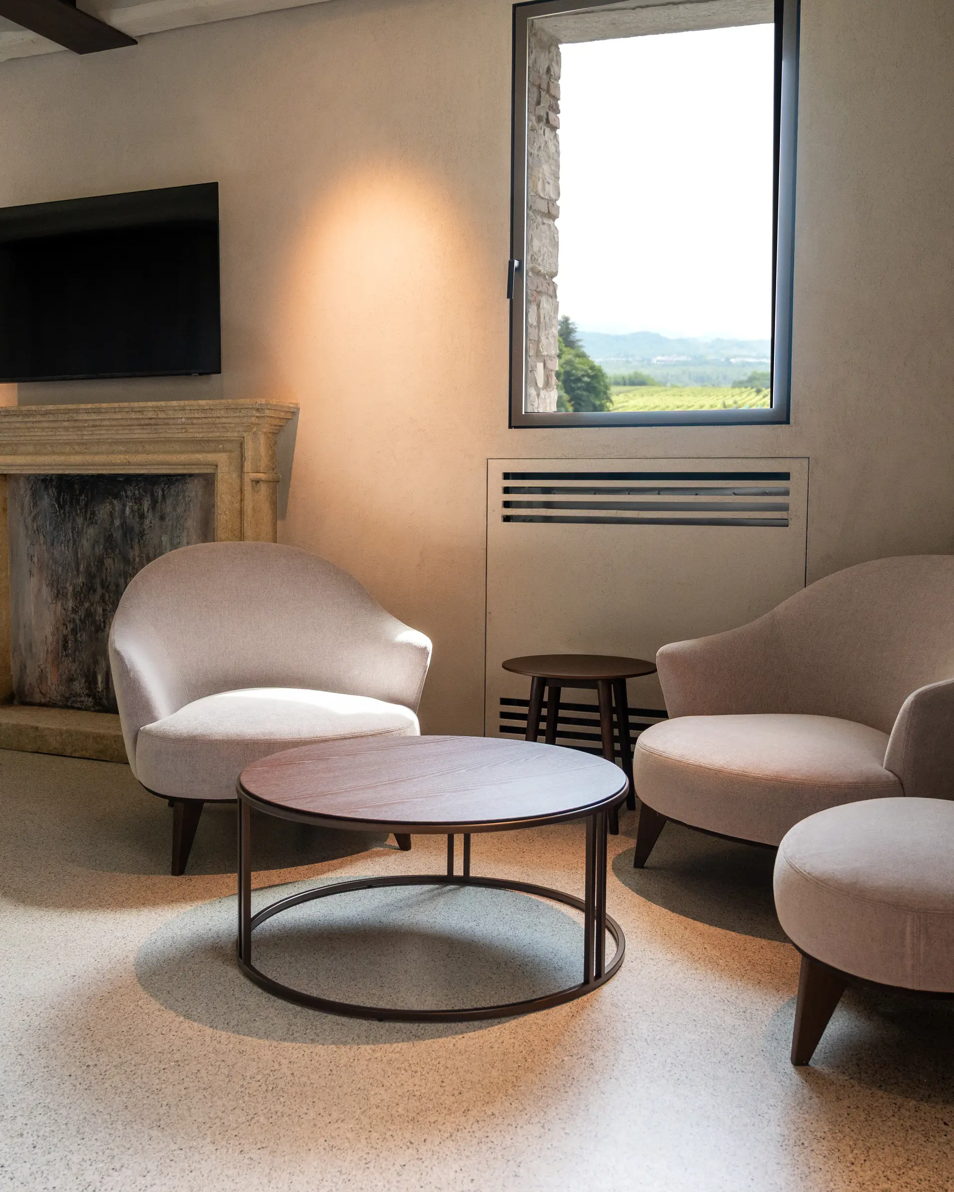 Suite im Borgo Taurino — separater Wohnbereich mit antikem Steinkamin und Blick auf die UNESCO-Weinberge
